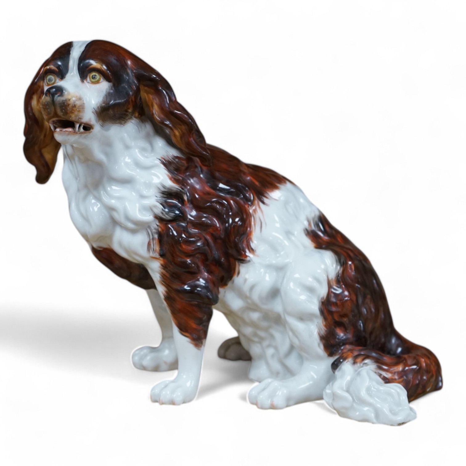 A Sitzendorf porcelain model of seated Spaniel, 21cm. Condition - repaired paw